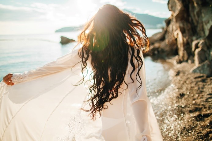 A person with long hair in a white dressDescription automatically generated with low confidence