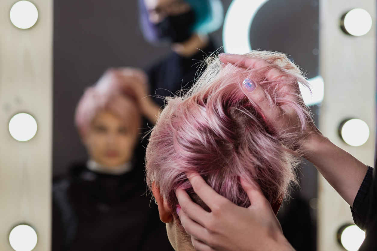 Woman with short pink hair at the hairdressers